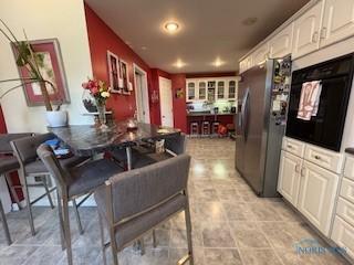 443 E 4th St, Ottawa, OH 45875 - kitchen with stainless steel refrigerator with ice dispenser, white cabinets, oven, and recessed lighting