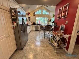443 E 4th St, Ottawa, OH 45875 - kitchen featuring vaulted ceiling, appliances with stainless steel finishes, dark countertops, glass insert cabinets, and white cabinetry