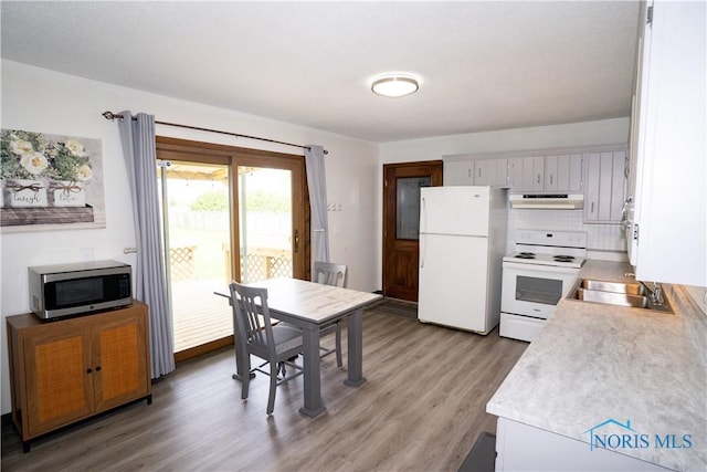 15480 State Route 18, Holgate, OH 43527 - kitchen with white appliances, under cabinet range hood, a sink, light countertops, and light wood-style floors
