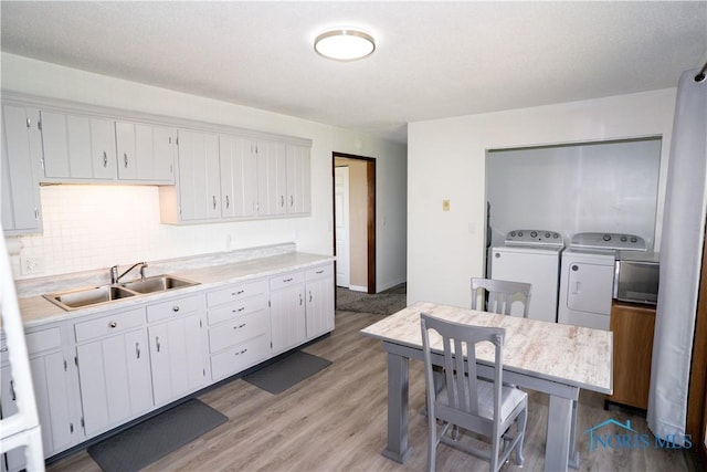 15480 State Route 18, Holgate, OH 43527 - kitchen featuring a sink, independent washer and dryer, light countertops, light wood-style flooring, and white cabinets