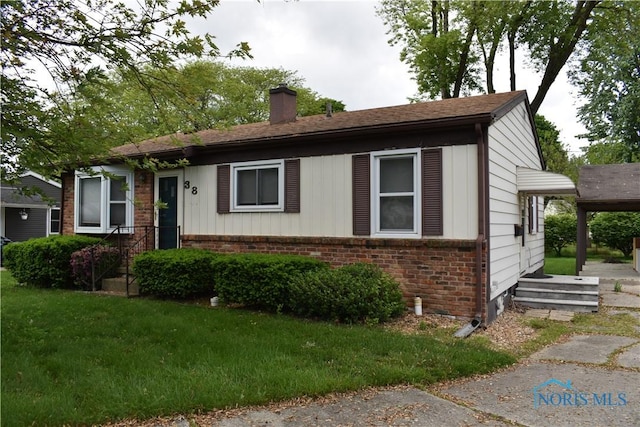 38 N Melody Ln, Waterville, OH 43566 - view of front of house with a chimney, brick siding, and a front yard