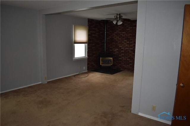 38 N Melody Ln, Waterville, OH 43566 - unfurnished living room featuring a wood stove, carpet, ceiling fan, and baseboards