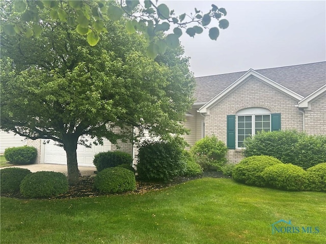 26347 W Wexford Dr, Perrysburg, OH 43551 - view of property exterior featuring brick siding, a yard, and a shingled roof