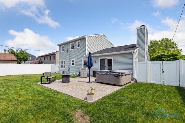 2546 Redfox Dr, Toledo, OH 43611 - back of house with a hot tub, a patio area, a chimney, and a gate