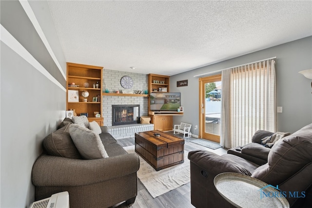 2546 Redfox Dr, Toledo, OH 43611 - living area featuring wood finished floors, a textured ceiling, and a fireplace
