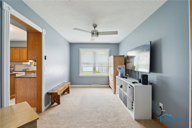 2546 Redfox Dr, Toledo, OH 43611 - sitting room with light colored carpet, a ceiling fan, a textured ceiling, and baseboards