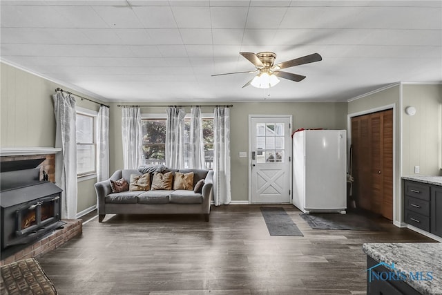 700 Franklin Ave, Findlay, OH 45840 - living room featuring ceiling fan, dark wood-style floors, ornamental molding, a wood stove, and baseboards