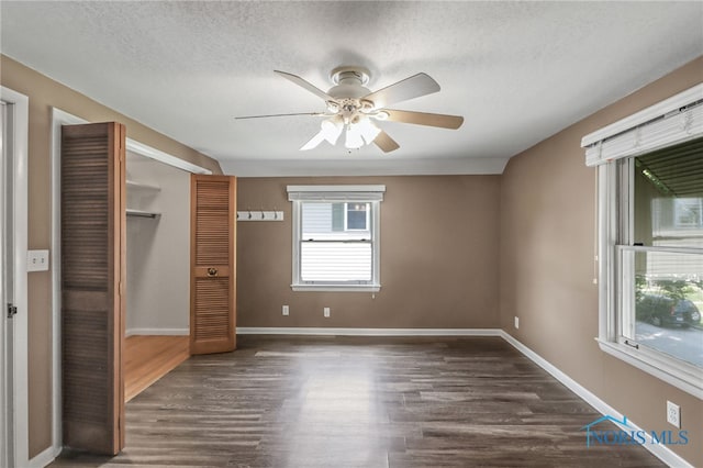700 Franklin Ave, Findlay, OH 45840 - unfurnished bedroom with dark wood-style flooring, a textured ceiling, a closet, baseboards, and ceiling fan