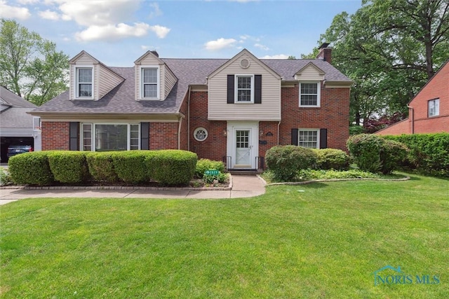 2829 Pembroke Rd, Ottawa Hills, OH 43606 - view of front of property with brick siding, a front yard, a chimney, and a shingled roof