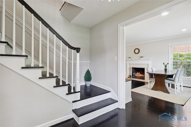 2829 Pembroke Rd, Ottawa Hills, OH 43606 - staircase with wood finished floors, a lit fireplace, crown molding, baseboards, and recessed lighting