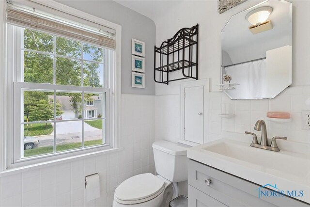 2829 Pembroke Rd, Ottawa Hills, OH 43606 - full bathroom with tile walls, vanity, toilet, and a wainscoted wall
