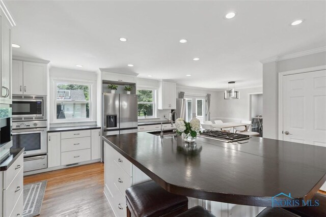 2829 Pembroke Rd, Ottawa Hills, OH 43606 - kitchen with appliances with stainless steel finishes, dark countertops, white cabinetry, crown molding, and a sink