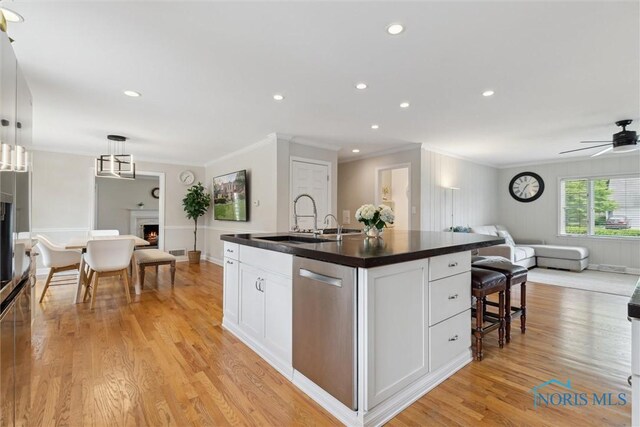 2829 Pembroke Rd, Ottawa Hills, OH 43606 - kitchen with dishwasher, open floor plan, a lit fireplace, dark countertops, and ornamental molding