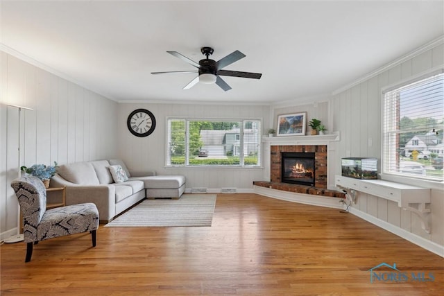 2829 Pembroke Rd, Ottawa Hills, OH 43606 - living room with ornamental molding, light wood-style floors, ceiling fan, and a fireplace