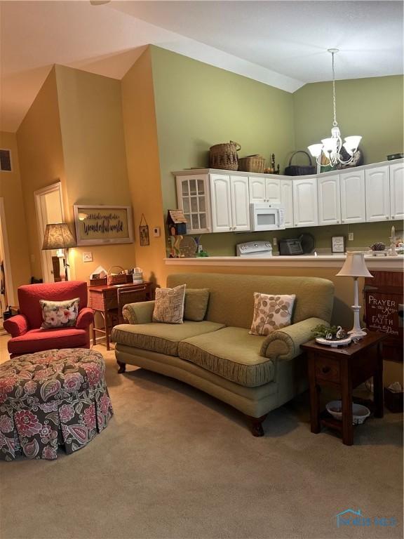 1245 Countryside Dr, Findlay, OH 45840 - carpeted living room featuring lofted ceiling and a chandelier