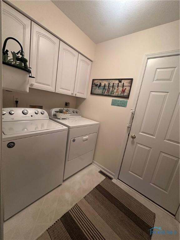 1245 Countryside Dr, Findlay, OH 45840 - laundry room featuring washer and dryer, cabinet space, and baseboards