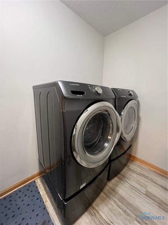 606 Polaris Dr, Upper Sandusky, OH 43351 - washroom featuring washing machine and dryer, baseboards, wood finished floors, and a textured ceiling