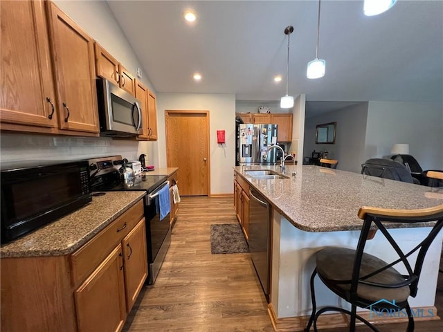 606 Polaris Dr, Upper Sandusky, OH 43351 - kitchen with appliances with stainless steel finishes, a sink, a breakfast bar, light wood-type flooring, and brown cabinetry