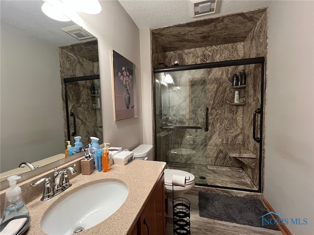 606 Polaris Dr, Upper Sandusky, OH 43351 - bathroom with toilet, vanity, a marble finish shower, a textured ceiling, and wood finished floors