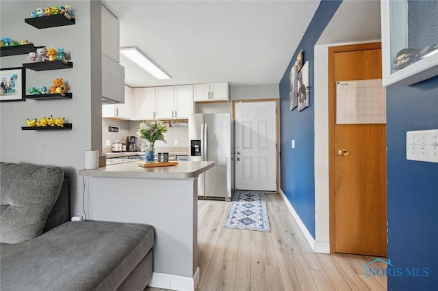 1058 Rockcress Dr, Toledo, OH 43615 - kitchen with stainless steel refrigerator with ice dispenser, white cabinetry, light wood-style flooring, light countertops, and open floor plan