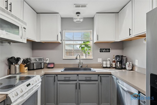 1058 Rockcress Dr, Toledo, OH 43615 - kitchen with white appliances, a sink, gray cabinets, and light countertops