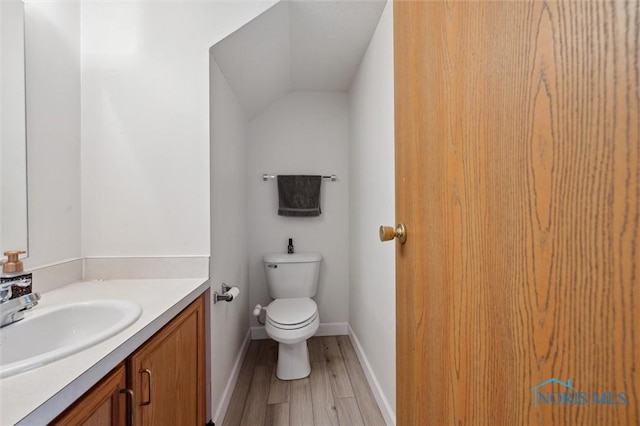 1058 Rockcress Dr, Toledo, OH 43615 - bathroom with vanity, wood finished floors, toilet, baseboards, and vaulted ceiling