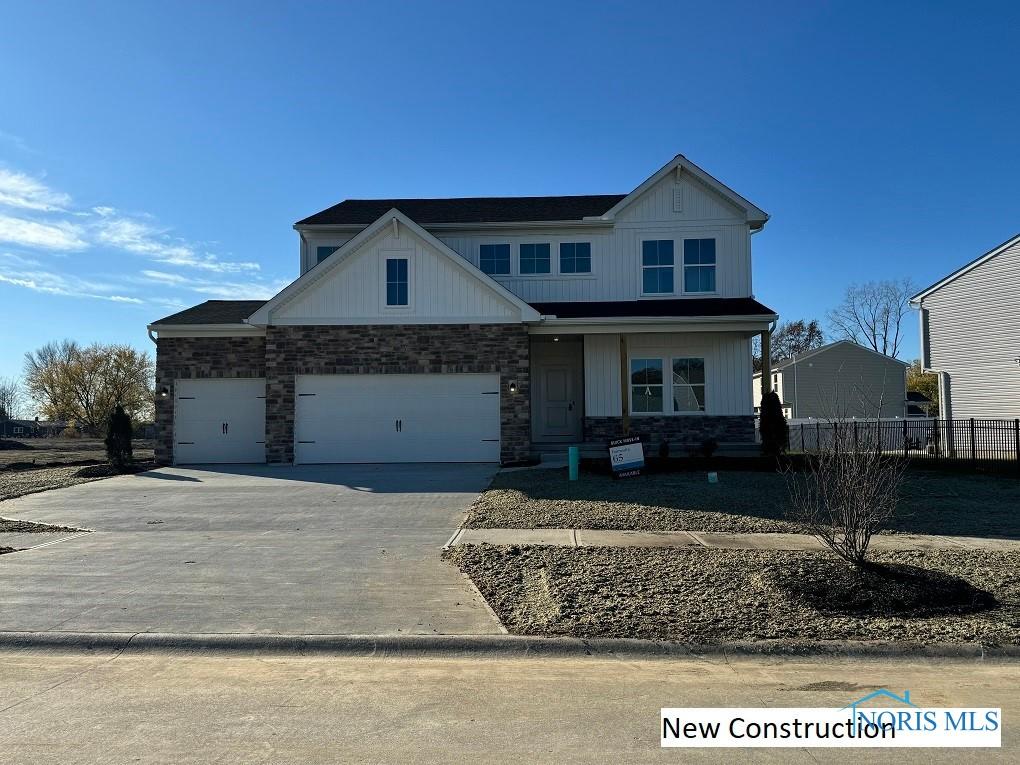 936 Darter Dr, Bowling Green, OH 43402 - view of front of home with stone siding, concrete driveway, and an attached garage