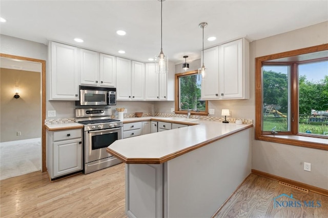 431 Hertford Ct, Maumee, OH 43537 - kitchen with stainless steel appliances, light countertops, a peninsula, white cabinets, and recessed lighting