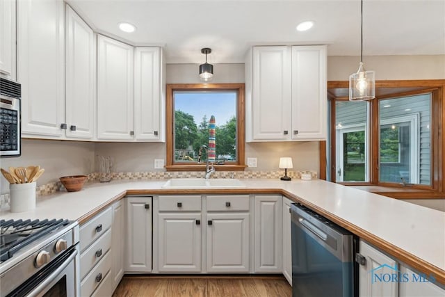 431 Hertford Ct, Maumee, OH 43537 - kitchen with appliances with stainless steel finishes, light countertops, white cabinets, and pendant lighting
