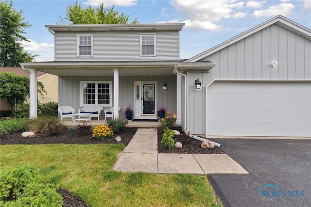 431 Hertford Ct, Maumee, OH 43537 - traditional-style house with covered porch, a garage, driveway, and a front lawn