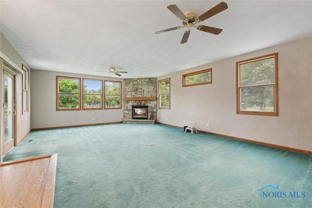 431 Hertford Ct, Maumee, OH 43537 - unfurnished living room featuring healthy amount of natural light, ceiling fan, a stone fireplace, and carpet