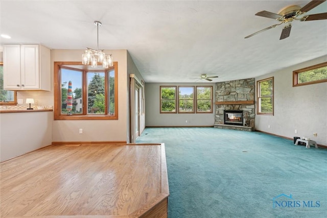 431 Hertford Ct, Maumee, OH 43537 - unfurnished living room with a ceiling fan, a chandelier, and a stone fireplace