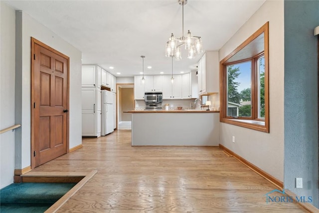 431 Hertford Ct, Maumee, OH 43537 - kitchen featuring stainless steel microwave, white cabinets, a peninsula, light wood-style floors, and recessed lighting