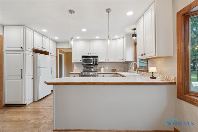 431 Hertford Ct, Maumee, OH 43537 - kitchen featuring stainless steel appliances, a peninsula, light countertops, light wood-style floors, and white cabinetry
