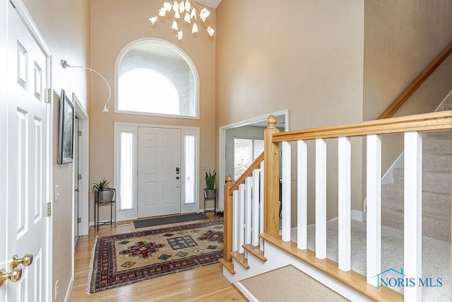 7559 Peachtree Ln, Sylvania, OH 43560 - foyer featuring a towering ceiling, a chandelier, stairs, and wood finished floors