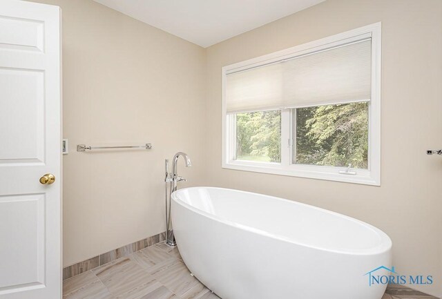 7559 Peachtree Ln, Sylvania, OH 43560 - bathroom featuring a soaking tub and baseboards