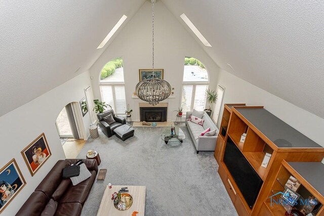 7559 Peachtree Ln, Sylvania, OH 43560 - carpeted living area featuring a skylight, high vaulted ceiling, a textured ceiling, healthy amount of natural light, and a fireplace