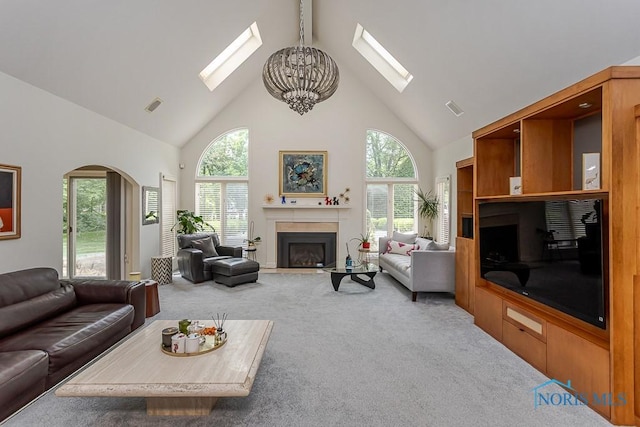 7559 Peachtree Ln, Sylvania, OH 43560 - carpeted living area with a skylight, high vaulted ceiling, a chandelier, a fireplace with flush hearth, and arched walkways
