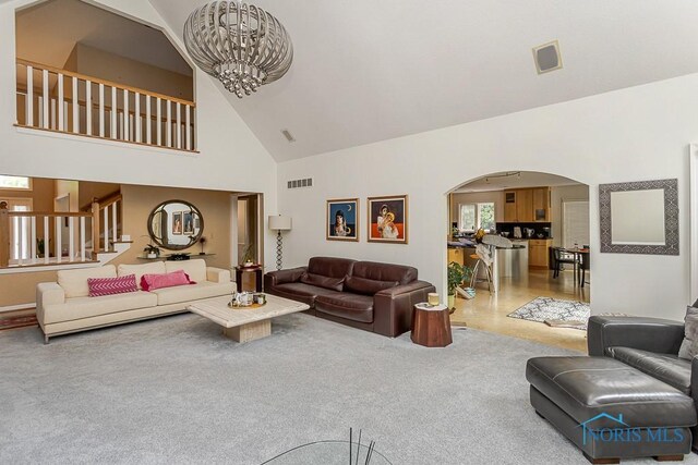 7559 Peachtree Ln, Sylvania, OH 43560 - carpeted living room with arched walkways, high vaulted ceiling, a chandelier, and stairway