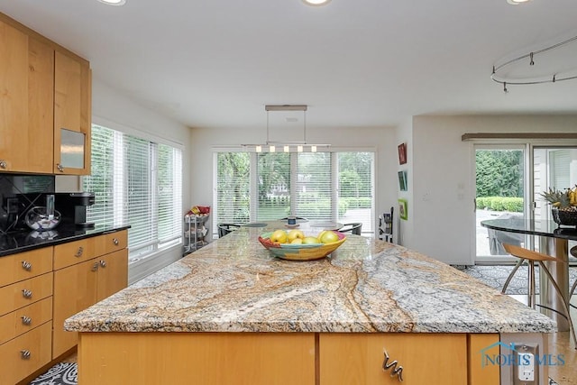 7559 Peachtree Ln, Sylvania, OH 43560 - kitchen featuring healthy amount of natural light, light stone countertops, a kitchen island, track lighting, and recessed lighting