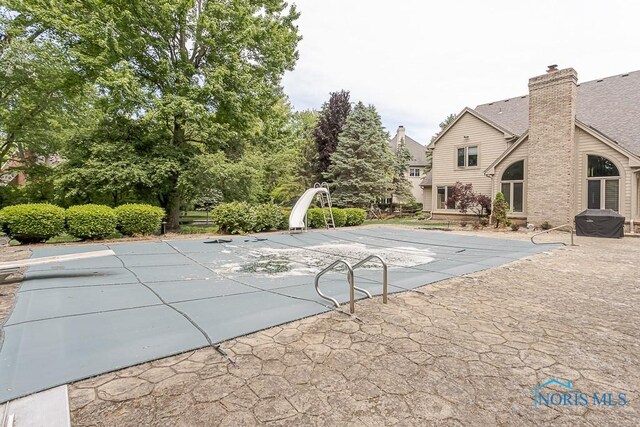 7559 Peachtree Ln, Sylvania, OH 43560 - view of pool with a water slide, a patio area, and a covered pool