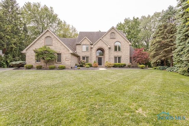 7559 Peachtree Ln, Sylvania, OH 43560 - french country style house featuring brick siding and a front lawn