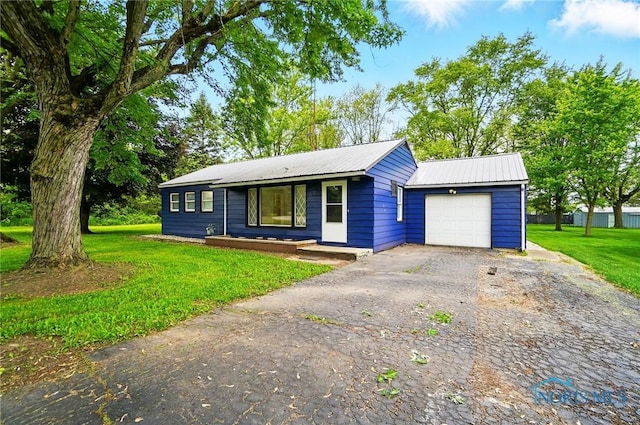 130 Vine St, Risingsun, OH 43457 - ranch-style house featuring asphalt driveway, a front lawn, metal roof, and a garage