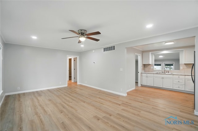 130 Vine St, Risingsun, OH 43457 - unfurnished living room featuring a sink, ceiling fan, light wood finished floors, crown molding, and baseboards
