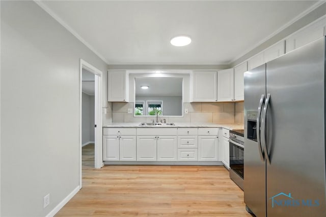 130 Vine St, Risingsun, OH 43457 - kitchen featuring stainless steel appliances, a sink, light wood-style floors, white cabinetry, and ornamental molding