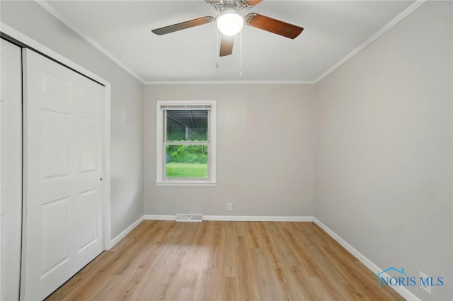 130 Vine St, Risingsun, OH 43457 - unfurnished bedroom featuring light wood finished floors, baseboards, crown molding, a closet, and ceiling fan