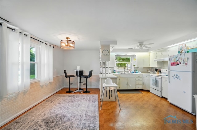 18827 State Route 2, Wauseon, OH 43567 - kitchen featuring white appliances, a sink, light countertops, under cabinet range hood, and a chandelier
