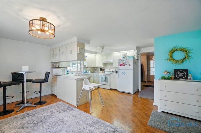 18827 State Route 2, Wauseon, OH 43567 - kitchen with white appliances, a peninsula, light countertops, ceiling fan, and white cabinetry