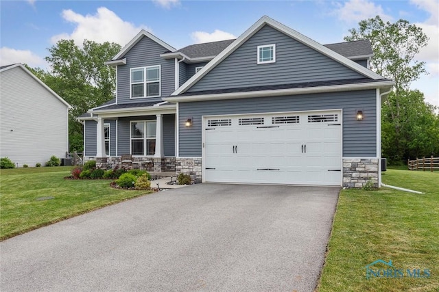 840 Wilkshire Dr, Waterville, OH 43566 - view of front of house with stone siding, driveway, covered porch, an attached garage, and a front lawn