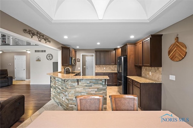 12158 Jefferson St, Perrysburg, OH 43551 - kitchen featuring open floor plan, freestanding refrigerator, stainless steel microwave, tasteful backsplash, and dark brown cabinets
